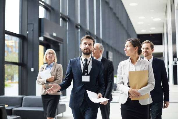 Handsome event planner holding tour for conference guests
